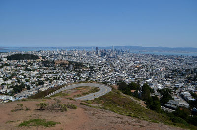 High angle view of city buildings against clear blue sky