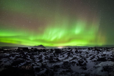 Scenic view of snow covered field against sky at night