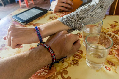 Midsection of woman with drink on table