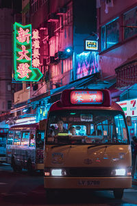 Illuminated sign on street in city at night