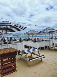 Chairs on beach against sky