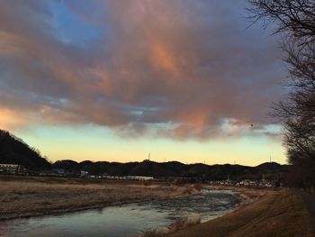 Scenic view of river against cloudy sky