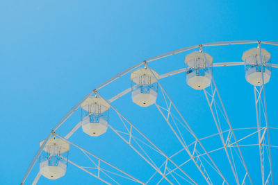 Low angle view of ferris wheel against blue sky