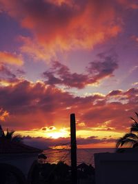 Scenic view of sea against dramatic sky during sunset