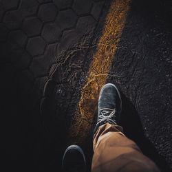 Low section of man standing walking on puddle during rainy season