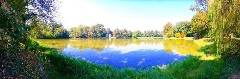 Scenic view of lake by trees against sky