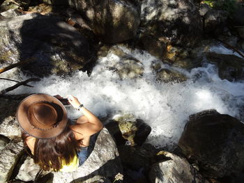 High angle view of person hand on rock