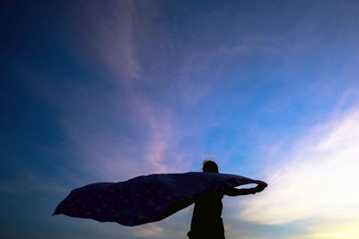 Low angle view of silhouette man standing against sky during sunset