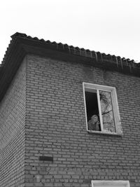 Low angle view of woman at building window