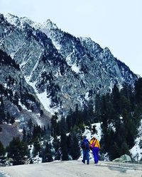 Rear view of man standing on snow covered mountain