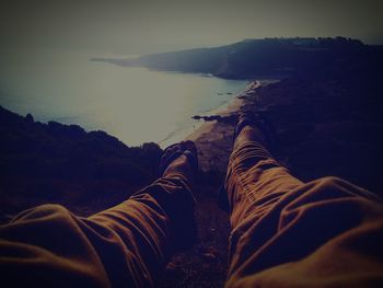 Low section of people relaxing on rock in sea