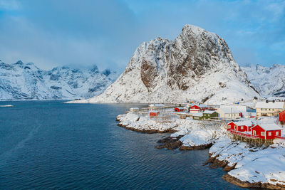 Scenic view of snowcapped mountains by sea against sky