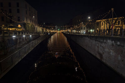 Illuminated bridge over canal in city at night