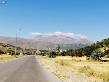 Road by landscape against sky