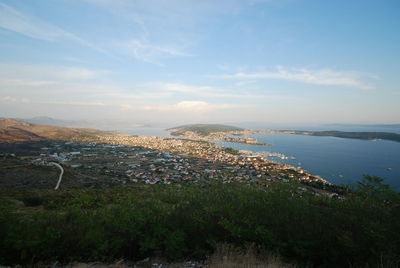 Aerial view of city by sea against sky