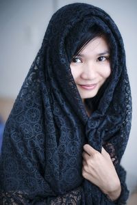 Portrait of young woman wearing scarf at home