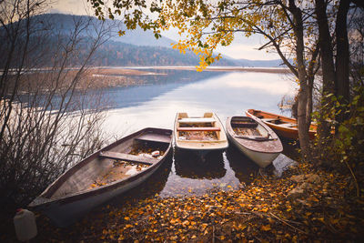 Scenic view of boats in calm lake in autumn