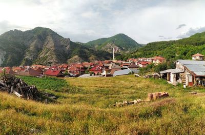 Scenic view of village by houses against sky