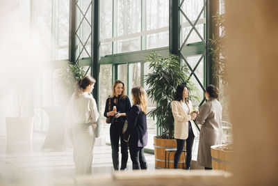 Smiling multi-ethnic female professionals networking in conference event