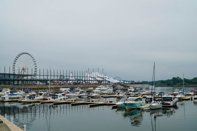 Boats moored at harbor against clear sky