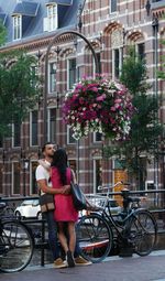 Woman with bicycle on street against buildings