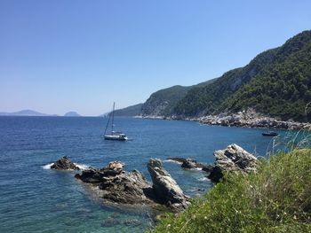 Sailboats in sea against clear sky