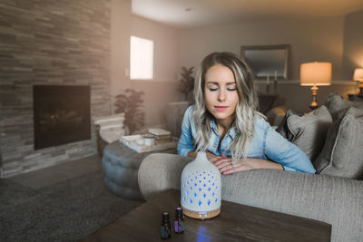 Young woman sitting on sofa at home