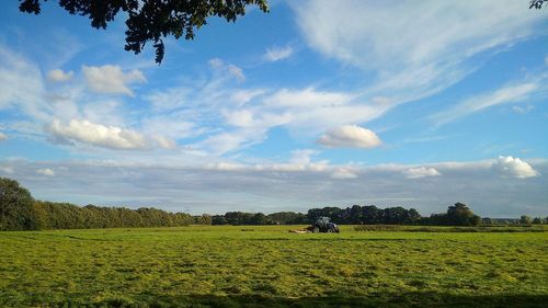 Scenic view of field against cloudy sky