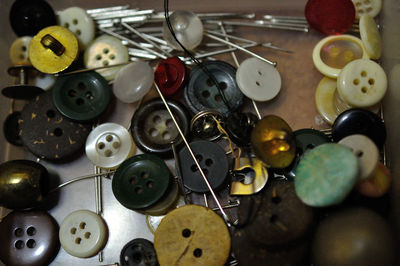 High angle view of needles and buttons
