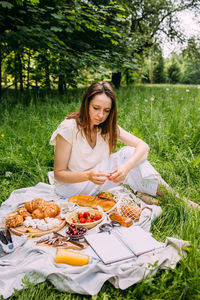 Beautiful woman on picnic. she smiles, eats strawberries and enjoys summer.