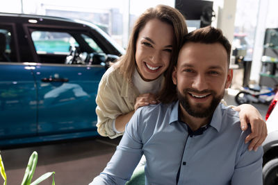 Portrait of couple at car showroom