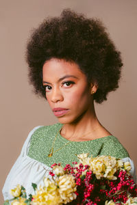 Portrait of young woman standing against wall