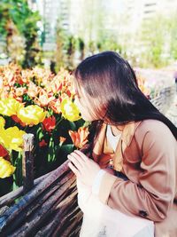 Close-up of girl smelling flowers outdoors
