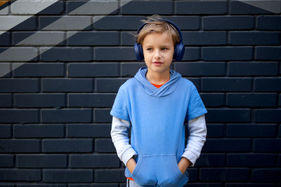 Portrait of boy against wall outdoors