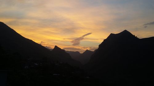 Silhouette of mountain against cloudy sky during sunset