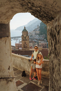 Portrait of family with two daughters and father against beautiful view of amalfi city
