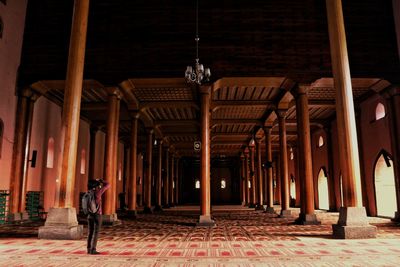 Rear view of woman standing in illuminated building