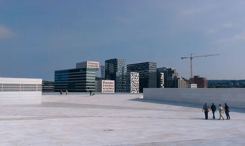 People walking on road against buildings