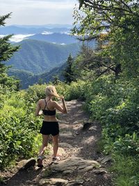 Rear view of woman standing on mountain road