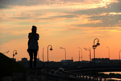 Silhouette city against sky during sunset