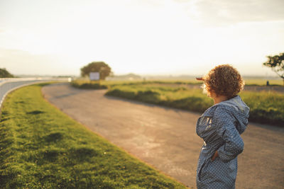 Rear view of boy standing on grass