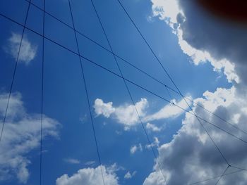 Low angle view of power lines against blue sky