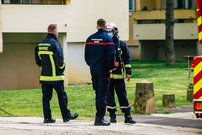 Full length rear view of men standing