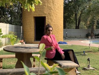 Full length of woman sitting on table at yard