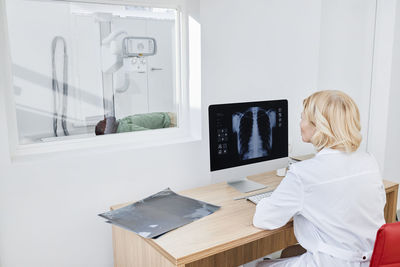 Radiologist taking x-ray shot of patient in clinic