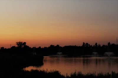 Scenic view of lake against romantic sky at sunset