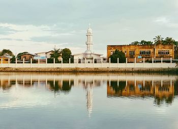 Reflection of church in water against sky