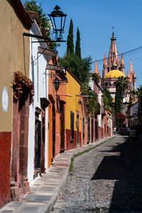 Alley amidst buildings in city against sky