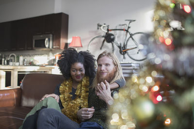 A young couple by a christmas tree