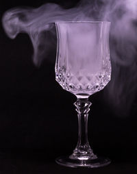 Close-up of wineglass on table against black background